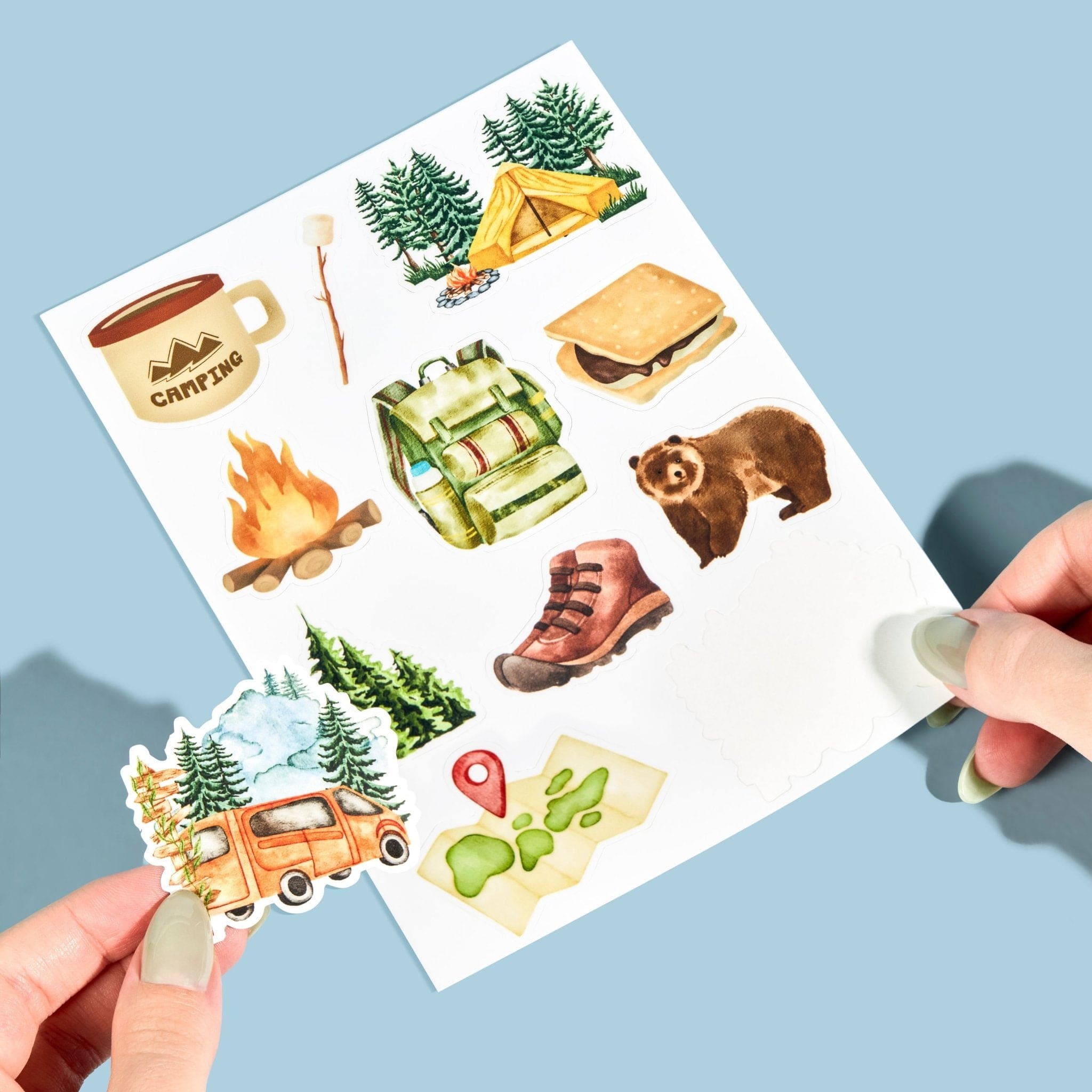 Custom sticker sheet featuring camping illustrations held in hand